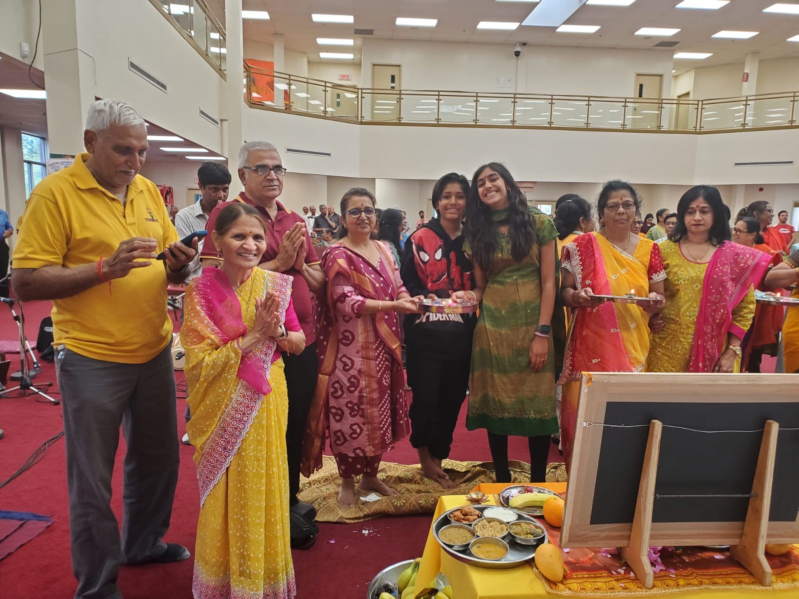 Families holding aarti thalis during the celebration