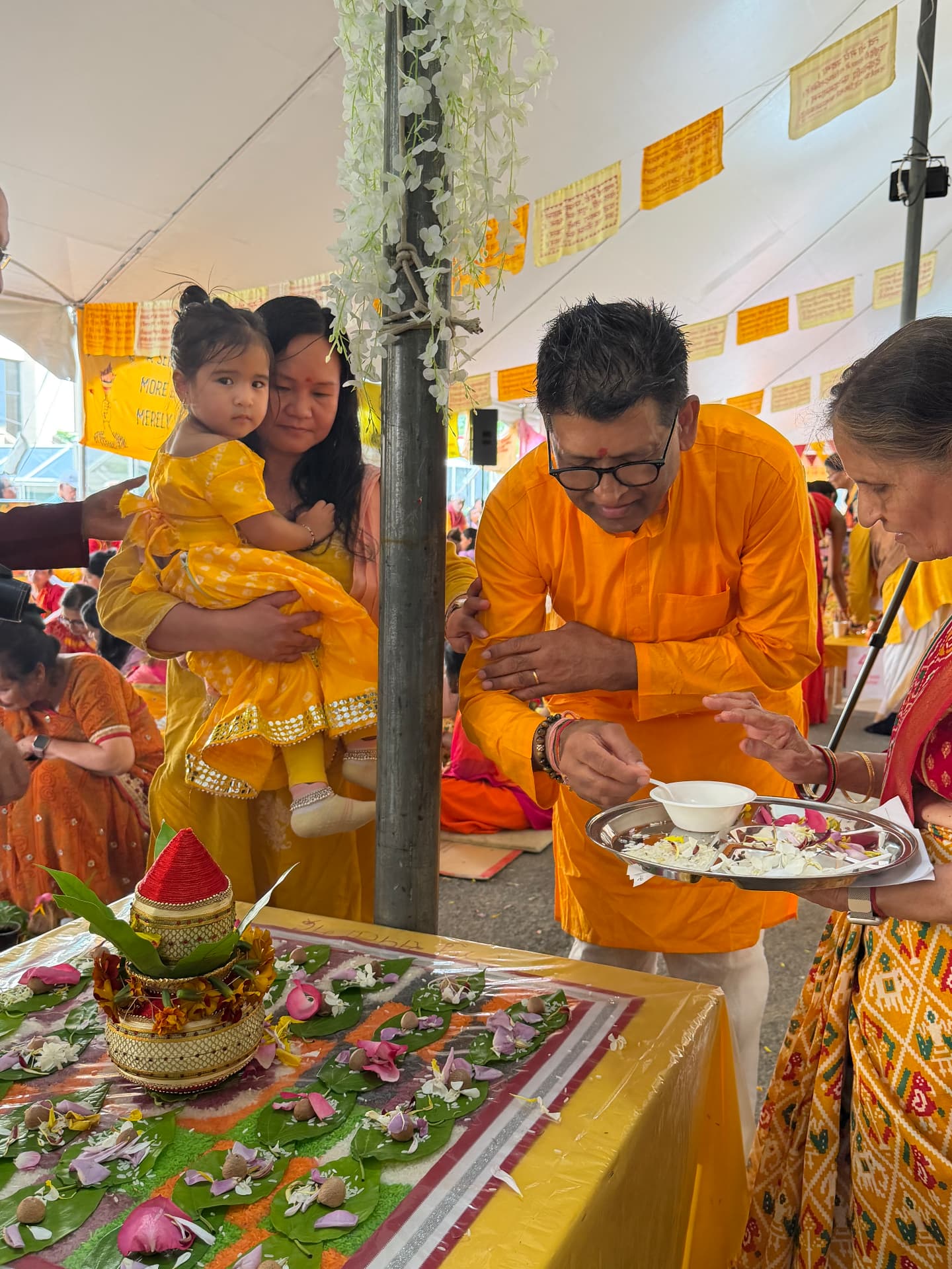Acharya offering aarti with families and children taking part