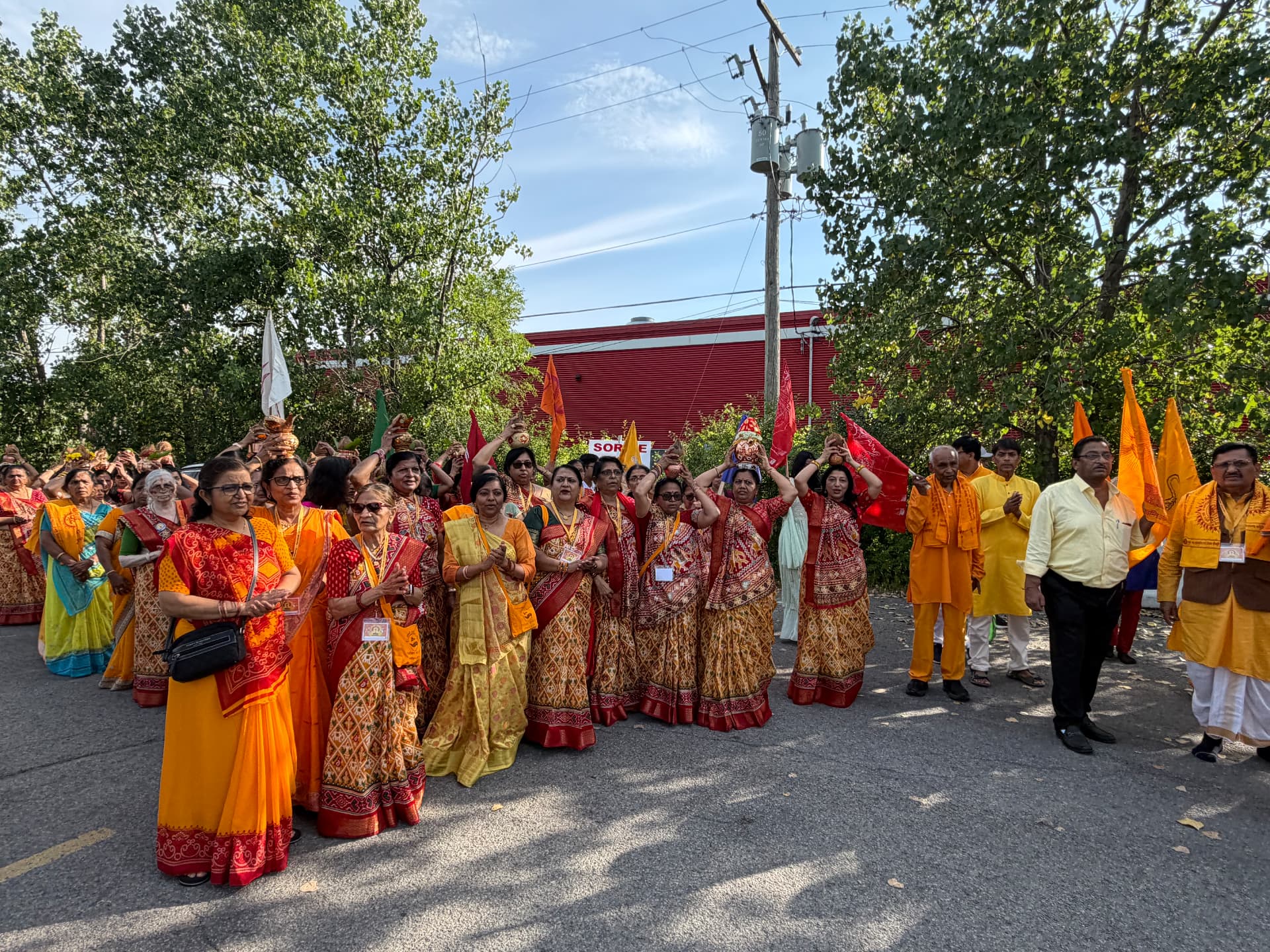 Kalash Yatra procession with flags outside the mandir