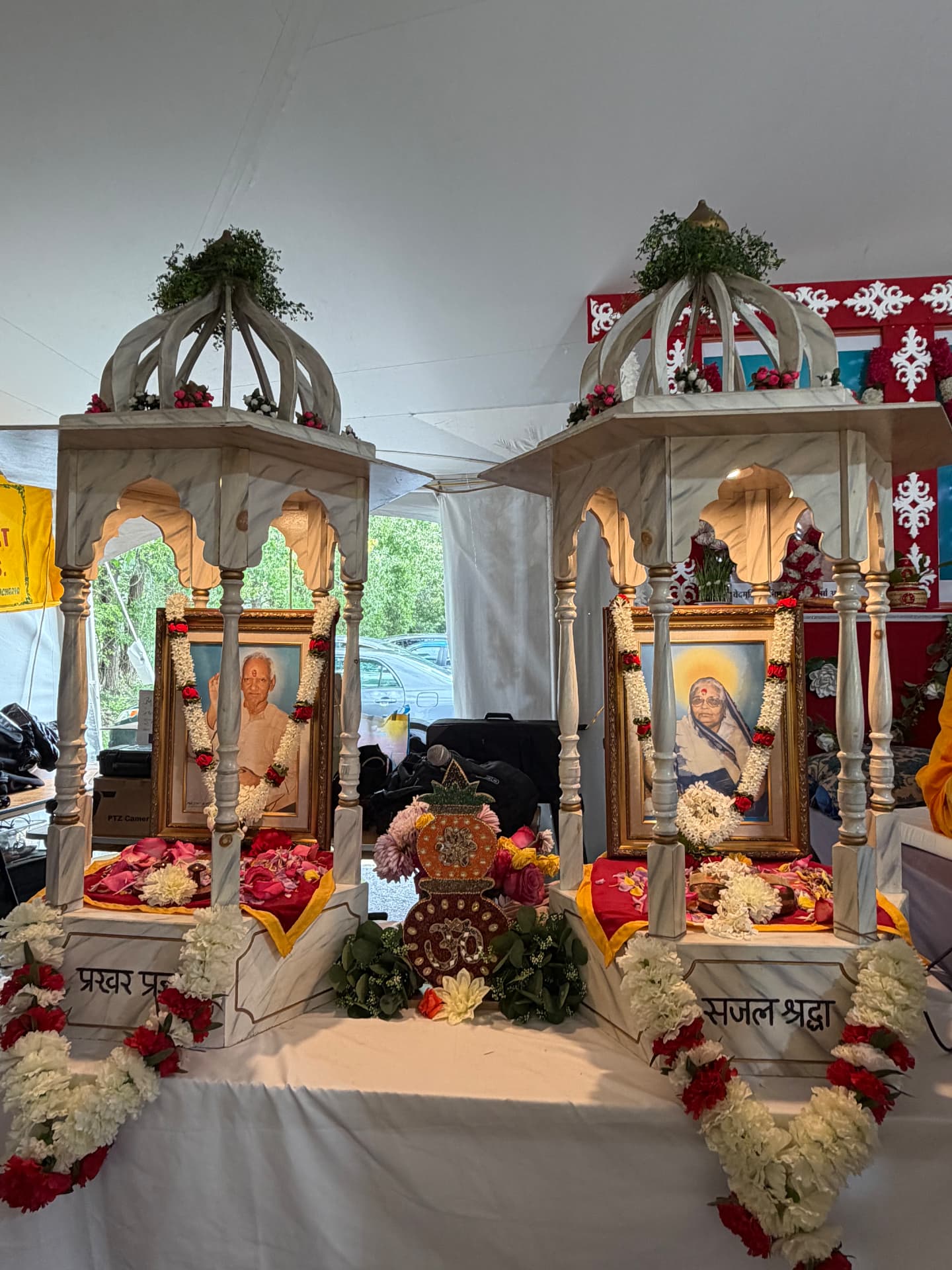 Garlanded portraits of Gurudev and Vandaniya Mataji at the altar